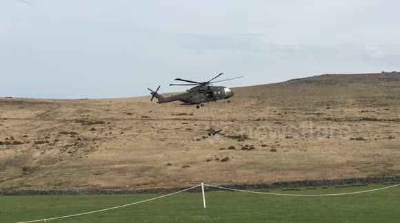 Military helicopter carrying artillery cannon wipes out row of portaloos