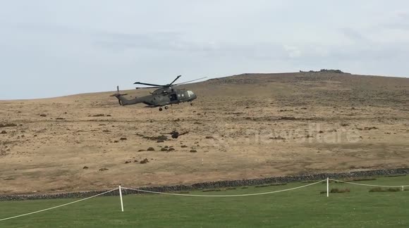 Military helicopter carrying artillery cannon wipes out row of portaloos