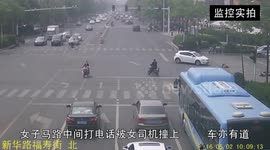 Electric bike driver talking on phone in the middle of the road is crashed by car