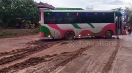 Minivan skids across muddy road after rain in Cambodia