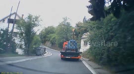 Tow truck loses load in front of other vehicle in traffic. Driver reaction wqs incredible.
