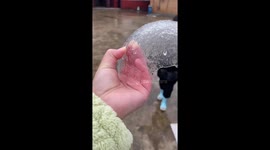 Sister puts frozen ice dome on her little brother's head like a hat