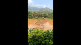 Moment bridge with locals walking across is swept away by flooded river in Vietnam