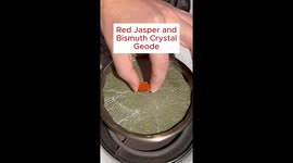 A bismuth crystal geode is made with a piece of red jasper as a seed.