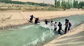 People hold rope in rushing water to rescue drowning woman