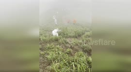 Chinese tourists battle to wind and rain to hike mountain