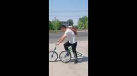 Chinese juggler impresses onlookers with his two-piece bike