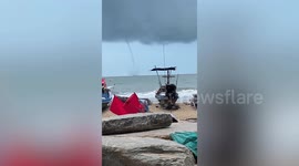 Elephant trunk tornado stretches from clouds to sea