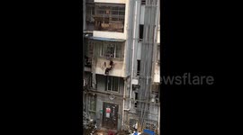 Heroic deliveryman saves elderly woman hanging from balcony of residential building in China
