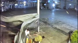 Tarpaulin uprooted by gusts sends Chinese men enjoying midnight snack tumbling outdoors