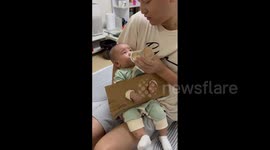 Chinese father's inventive cardboard 'handcuffs' ensure baby's milk time success
