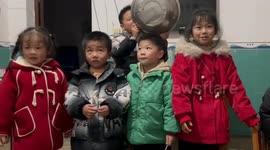 Chinese children play fun game with metal basin