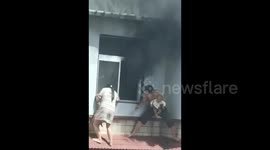 Desperate couple crawl out of window with babies in hand to narrowly escape fire