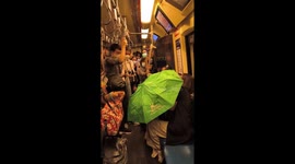 Passengers use umbrellas as water pours into subway train in Bangkok