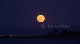 Huge full Flower Moon blossoms in the night sky over Greece