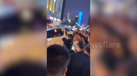 Crowd works to lift car off man trapped after collision