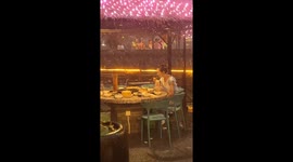 Girl enjoys hot pot in torrential rainstorm in China