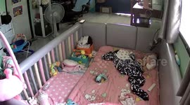 Mum scoops up baby fiddling with power strip in crib