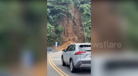 Woman is almost crushed and flees as mountain collapses onto road