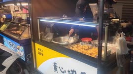 Talented vendor skillfully moves fried food balls to tray