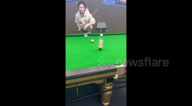 China: A girl makes an impressive pool shot, sinking the ball into the pocket