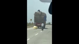 Thieves on motorbikes steal good from back of moving lorry in India