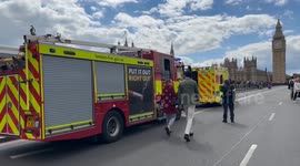 Fire trucks, ambulances on Westminster Bridge, rescue boats in River Thames for apparent search mission