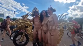 Bare cyclist poses with magnificent gold bike in the Mall during the World Naked Bike Ride
