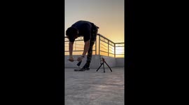 Young man does pushups on the point of an axe with perfect balance