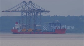 Ship departs Thames with two giant cranes balanced on deck off Kent, UK