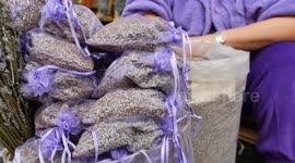 A stack of purple lavender bags fills the basket, creating a beautiful pattern