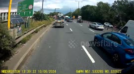 A white van with two men wearing masks inside cuts across lanes of traffic and then drives the wrong way up a slip road after mounting a curb.