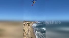 Stranded surfer spelled out 'HELP' with rocks before being rescued by chopper