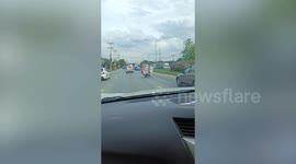Motorcycle overloaded with rolls of string topples over