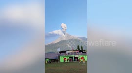 Footballers continue playing as volcano erupts behind them