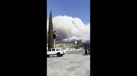 Fast-moving Post Fire, near Los Angeles - a spectacular shot of a plane dropping pink fire retardant, directly into huge smoke clouds