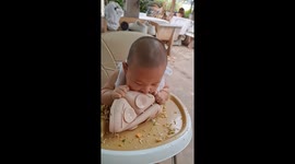 Baby makes a mess learning to eat from plate