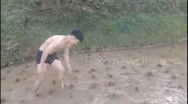 China: Man Sprints Across Muddy Field in Liuzhou