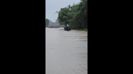 Diggers power through flooded road amid heavy rain