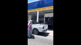 Clever woman rides scooter seated on suitcase in Cancún