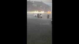Locals wade through flooded road in China