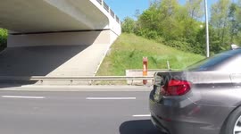 11MH4916 BMW gives the finger while texting as he drives his kids on the M50 M1 Dublin Ireland