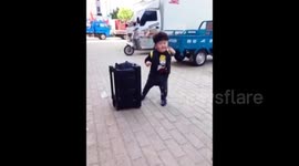 Little boy dances enthusiastically to music on the street