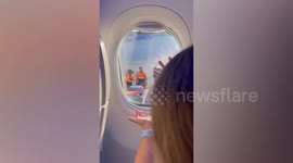 Ground crew play rock paper, scissors with departing plane passengers