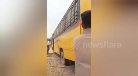 Train makes emergency stop to avoid hitting school bus stuck on tracks in eastern India