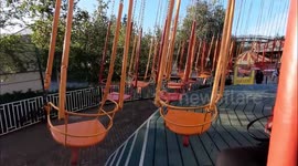 Solstice sun glints through merry-go-round swing ride in Kent, UK