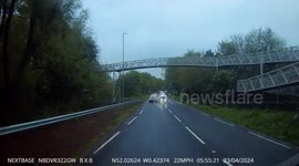 Inpatient car overtaking dangerously when exiting a traffic island narrowly avoiding a crash.