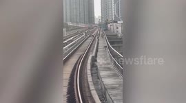Wild monkey holds up trains as it scampers across tracks in Bangkok