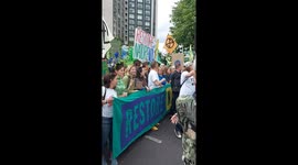 Stewards manage the crowd as celebrities assemble at the start of the UK's biggest ever march for nature & climate