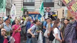 Protestors march past Green Park, London, on the UK's biggest ever march for nature & climate